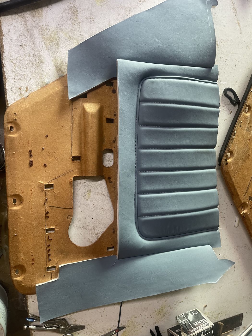 Door panel being covered in gray vinyl