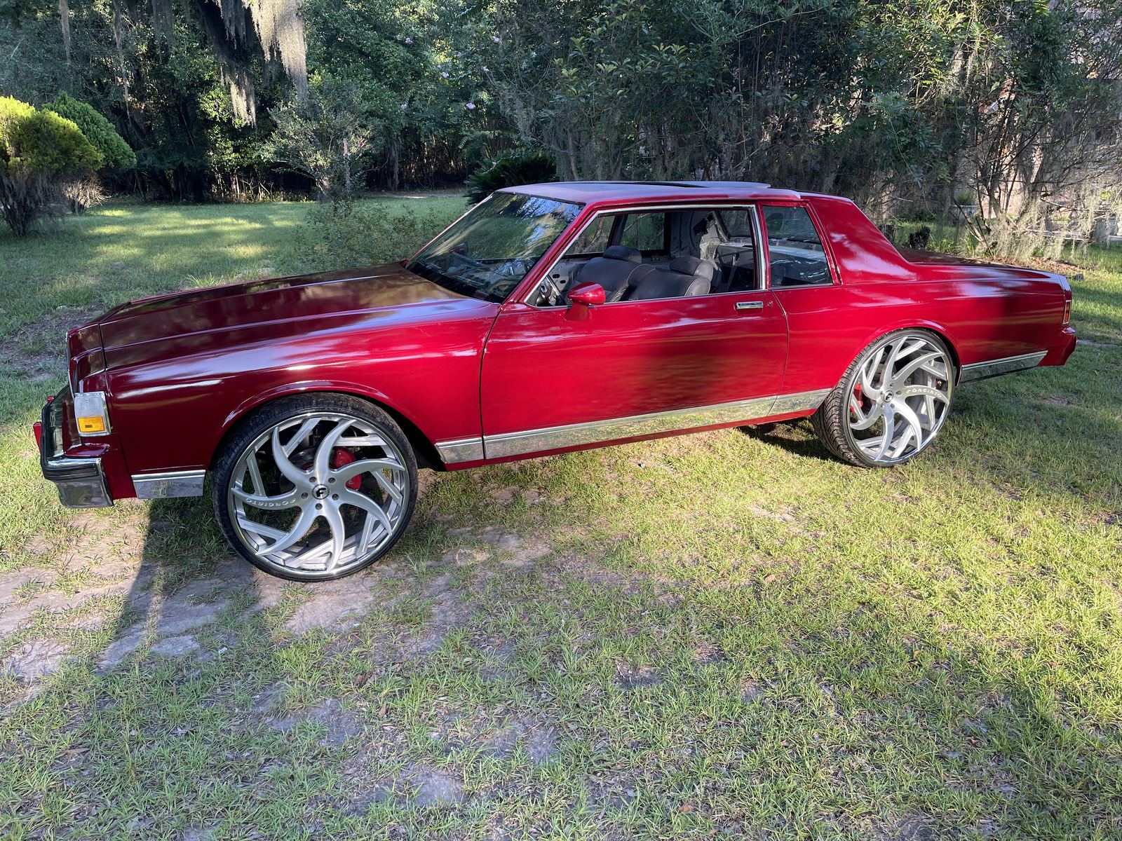Red Chevrolet Caprice coupe on custom wheels